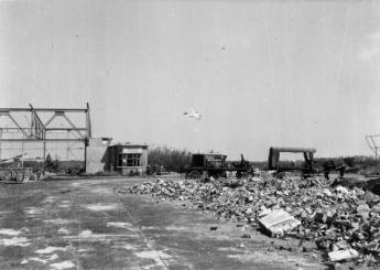 B-17 nadert platgebombardeerde vliegveld Bergen met hangaar 3 in May 1945